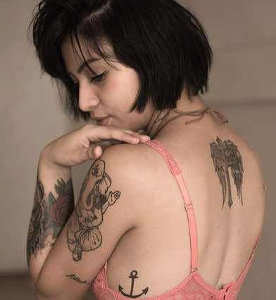 Girl with tattoo on arm and back