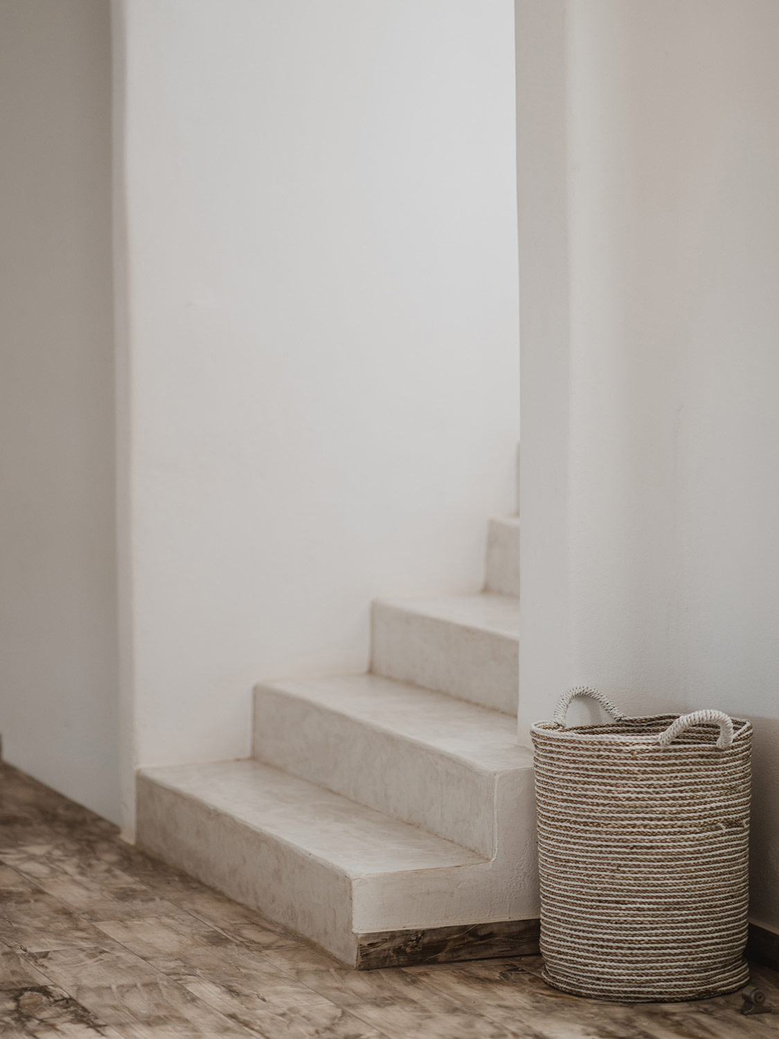 Rustic white staircase with a cord basket