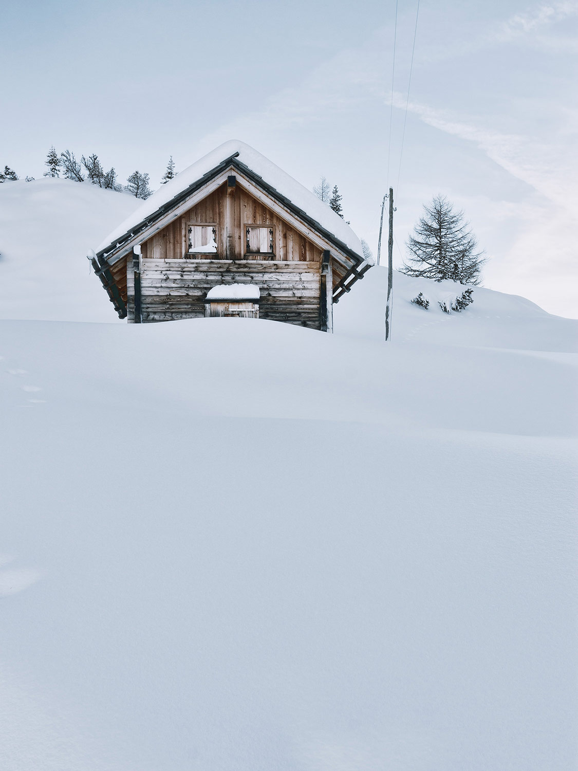 A wooden cabin on snowy hills